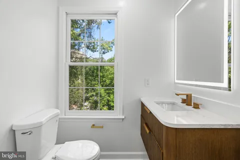 a bathroom with a sink a toilet and a window