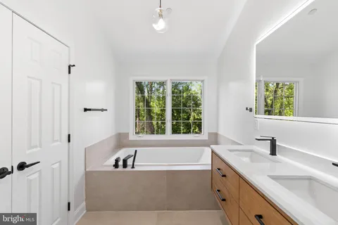 a bathroom with a granite countertop sink and a bathtub