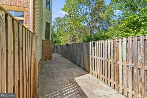 a view of a pathway of a building with wooden fence