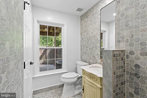a bathroom with a granite countertop toilet a sink and a shower