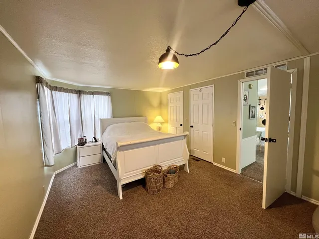 a spacious bedroom with a bed and a cabinets