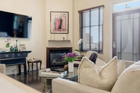 a living room with stainless steel appliances furniture a couch and a kitchen view