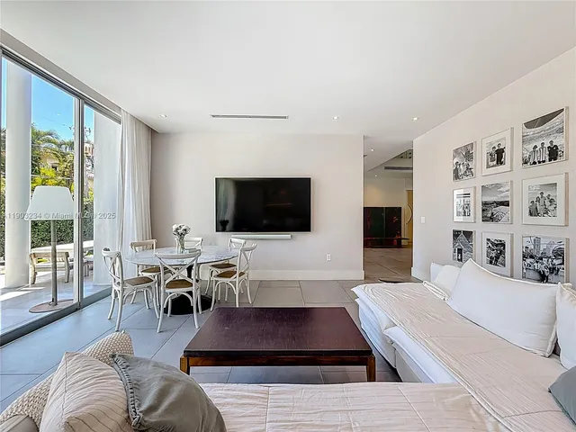 a living room with furniture a flat screen tv and a large window