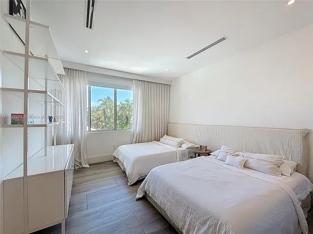 a bedroom with two beds and a large window