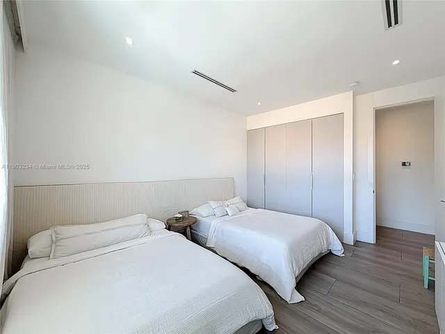 a bedroom with two bed and a night stand