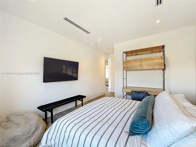 a bedroom with a bed and a flat screen tv
