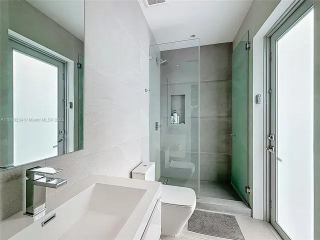 a bathroom with a sink toilet and shower