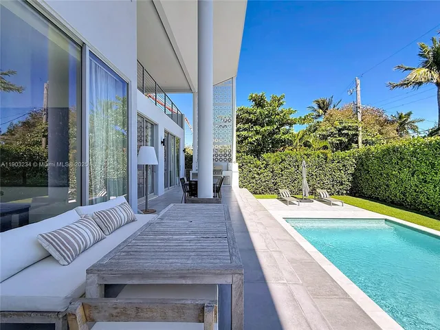 a view of a patio with couches plants and wooden floor