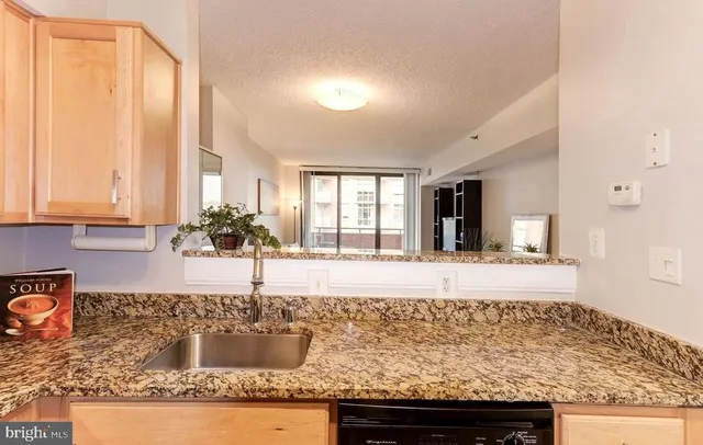 a kitchen with stainless steel appliances granite countertop a refrigerator a stove a sink and a microwave