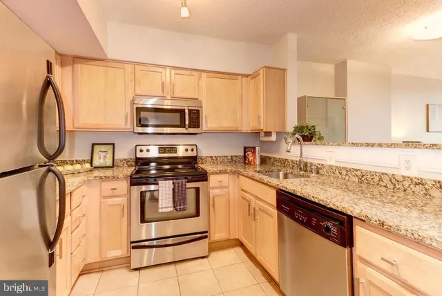 a kitchen with granite countertop sink and cabinets