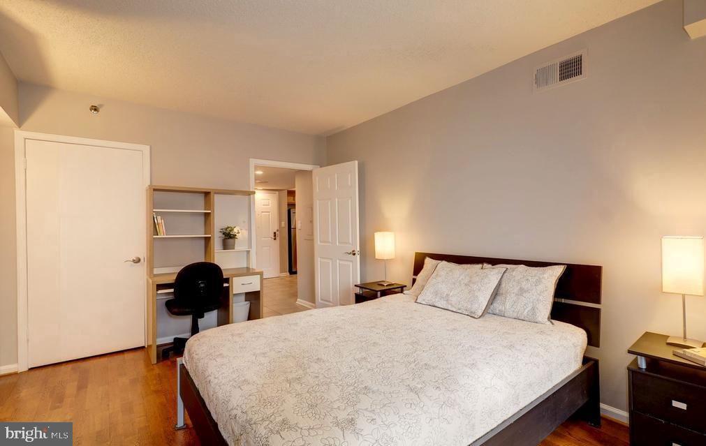 1001 North Randolph Street, Unit 406 Arlington, VA 22201 - Photo 7 of 23 a bedroom with a bed and wooden floor