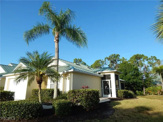 a view of a house with a yard and palm trees