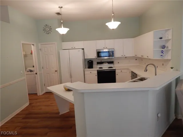 a kitchen with kitchen island a stove a sink and a refrigerator