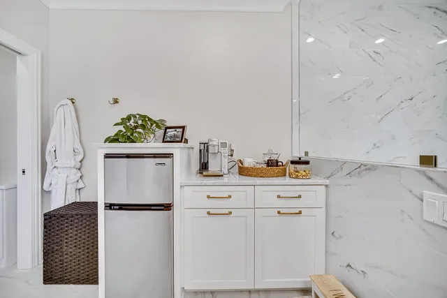 a bathroom with a granite countertop sink a toilet a mirror a vanity and shower