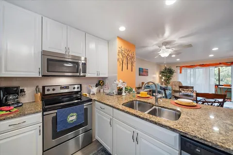 a kitchen with stainless steel appliances granite countertop a refrigerator sink and stove
