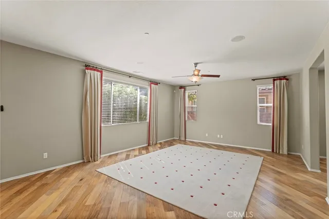 a view of a livingroom with wooden floor and a ceiling fan