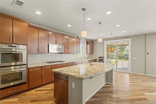 a large kitchen with kitchen island a large counter space a sink appliances and cabinets