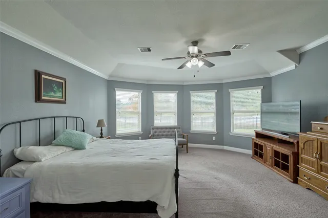 a spacious bedroom with a bed a couch and a chandelier