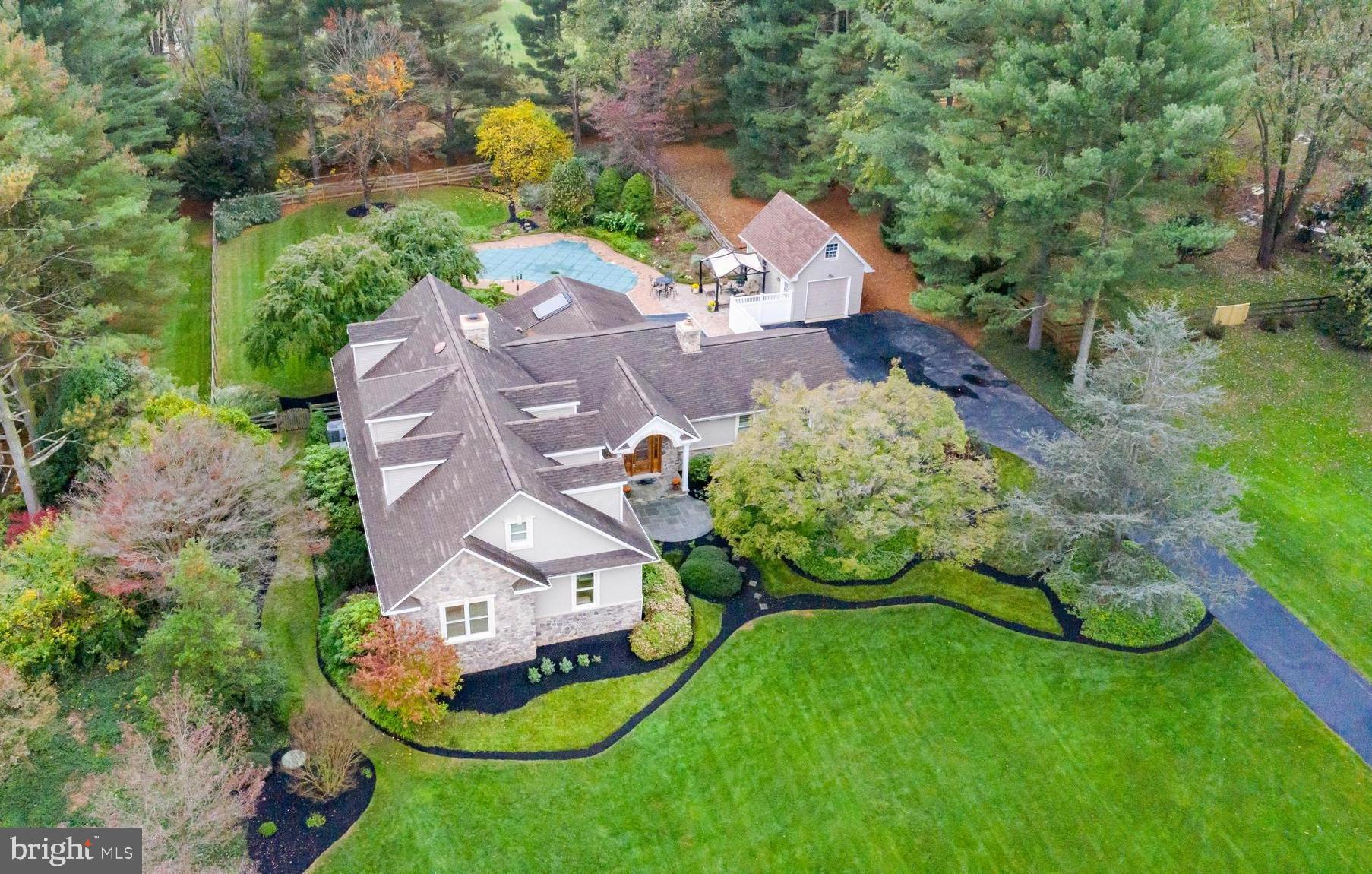 an aerial view of a house with a garden and lots of trees