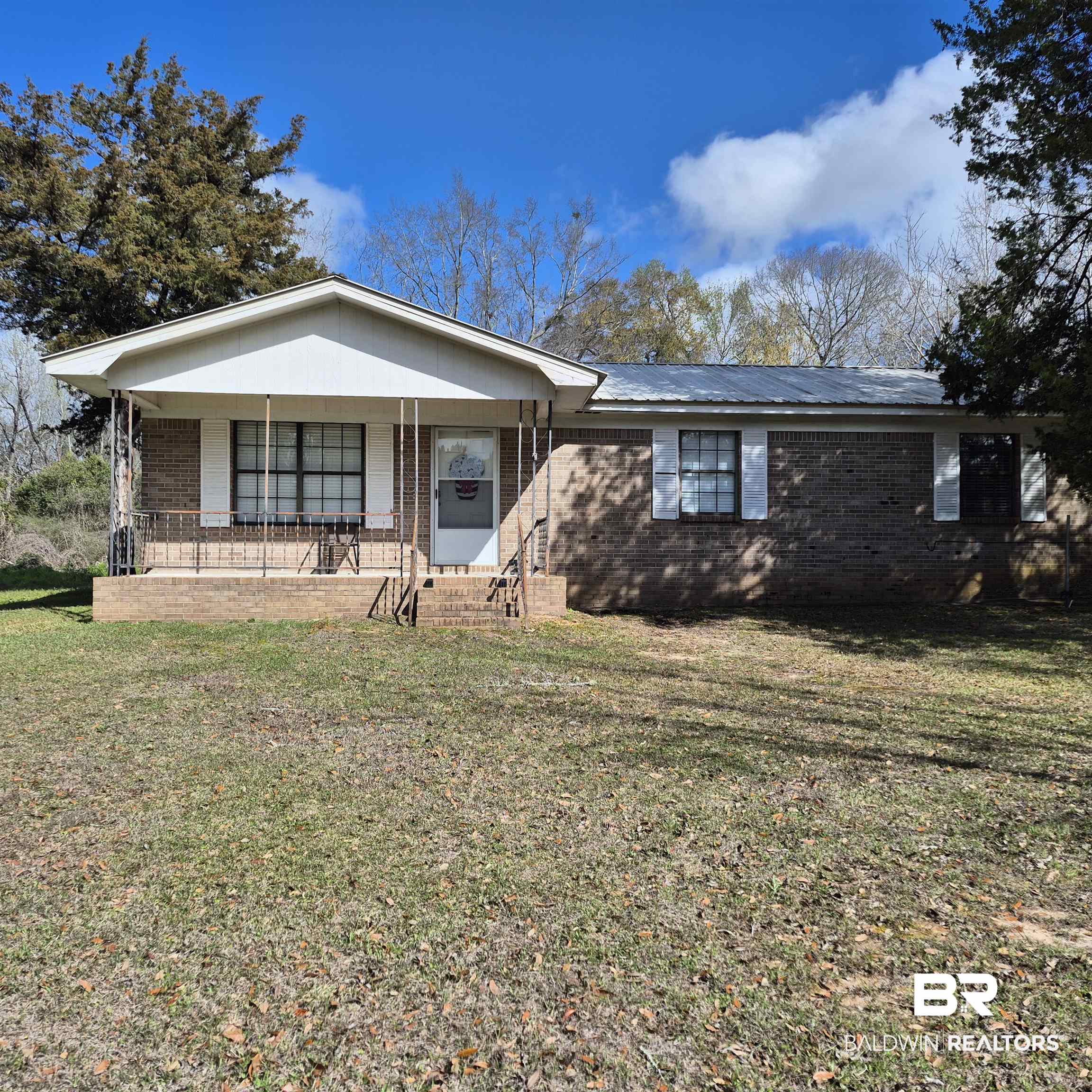 721 Perryman Street Evergreen, AL 36401 - Photo 1 of 26 Ranch-style home featuring a porch, brick siding, and a front yard