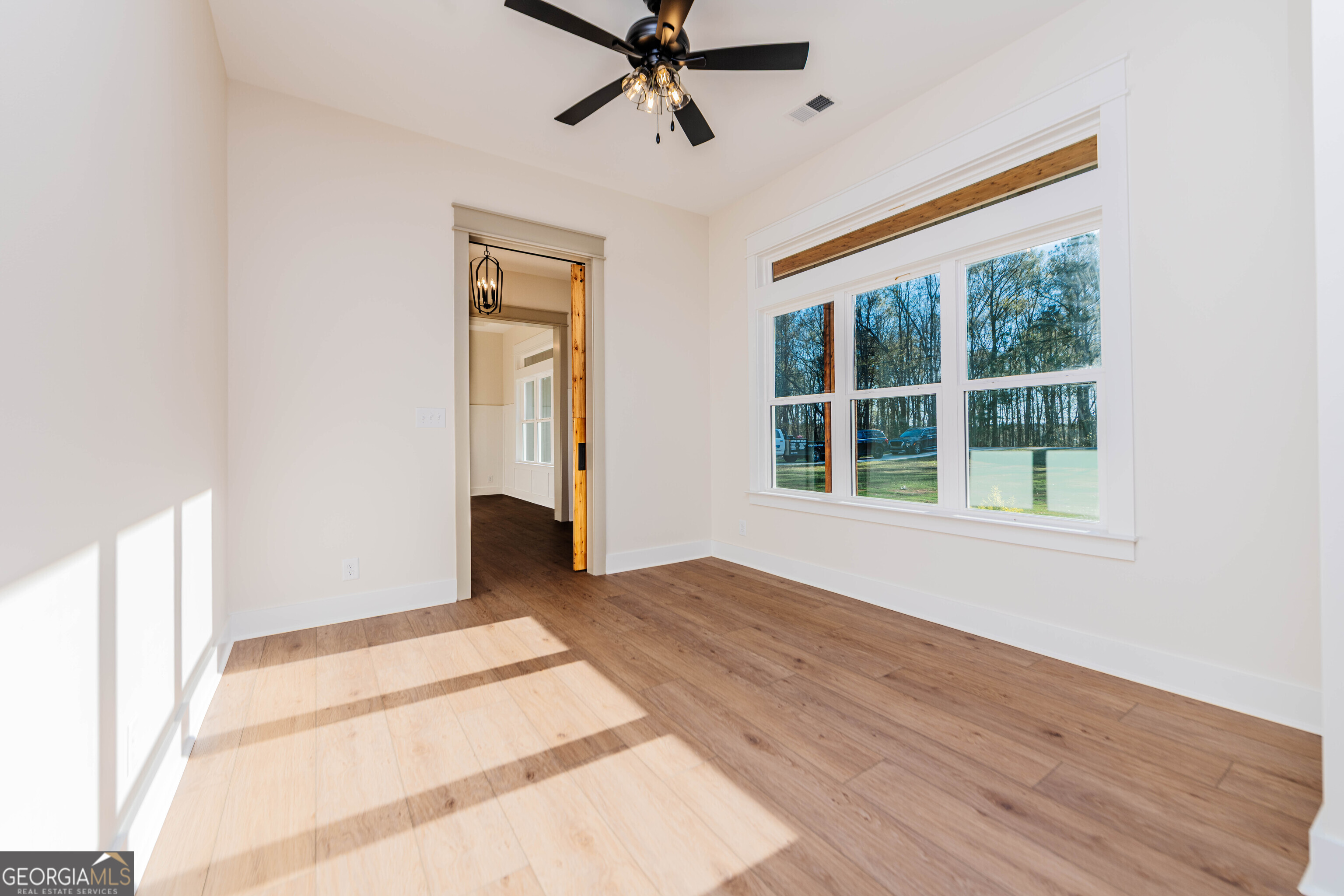 2089 Willow Lake Road Fort Valley, GA 31030 - Photo 6 of 50 a view of an empty room with a window and wooden floor