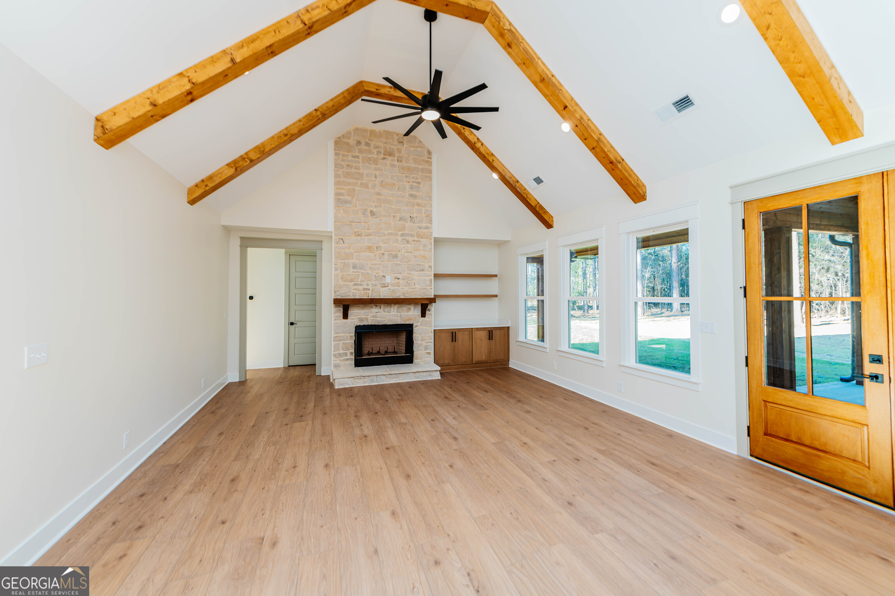 2089 Willow Lake Road Fort Valley, GA 31030 - Photo 7 of 50 a view of an empty room with wooden floor and a fireplace