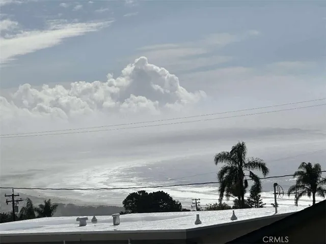 a view of a patio with lawn chairs under an umbrella