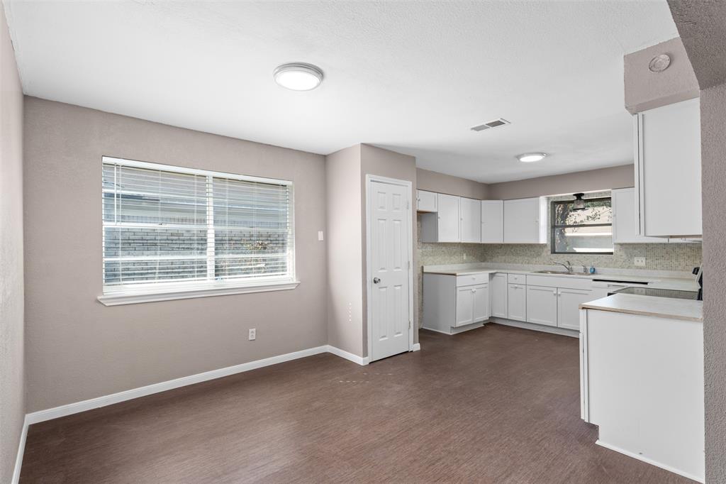 a kitchen with white cabinets and white appliances