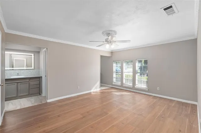 a view of an empty room with a window and wooden floor