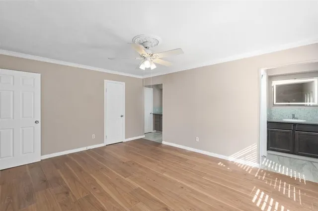 a view of an empty room with window and a kitchen