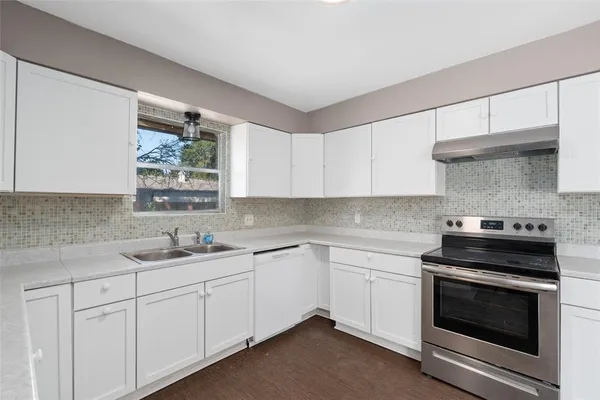 a kitchen with a sink stove and cabinets
