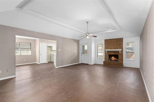an empty room with wooden floor fireplace and cabinet