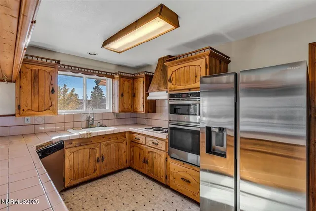 a kitchen with stainless steel appliances kitchen island granite countertop a sink stove and refrigerator
