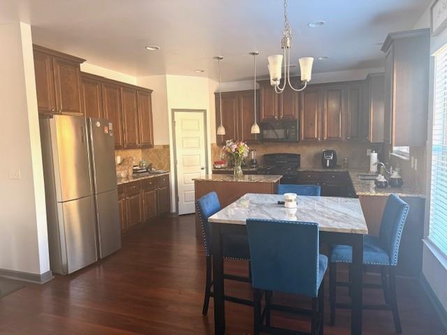 12149 Centerra Drive Hampton, GA 30228 - Photo 18 of 48 a kitchen with a dining table chairs refrigerator and cabinets
