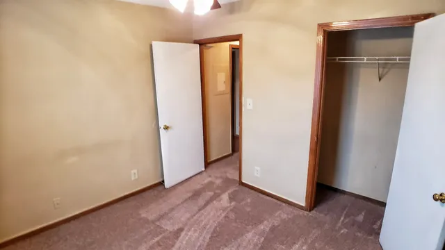 an empty room with closet and a window