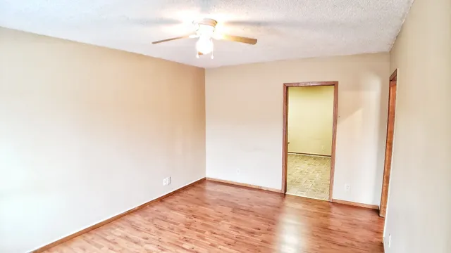 a view of an empty room with wooden floor