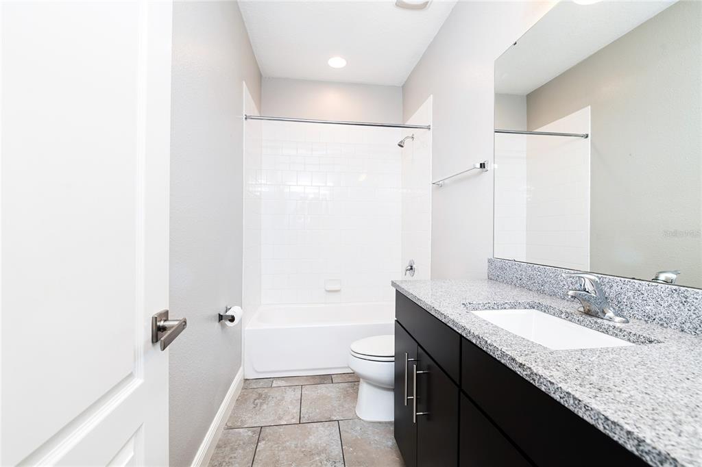 8555 Pinter Street Orlando, FL 32827 - Photo 6 of 32 a bathroom with a granite countertop sink a toilet and shower