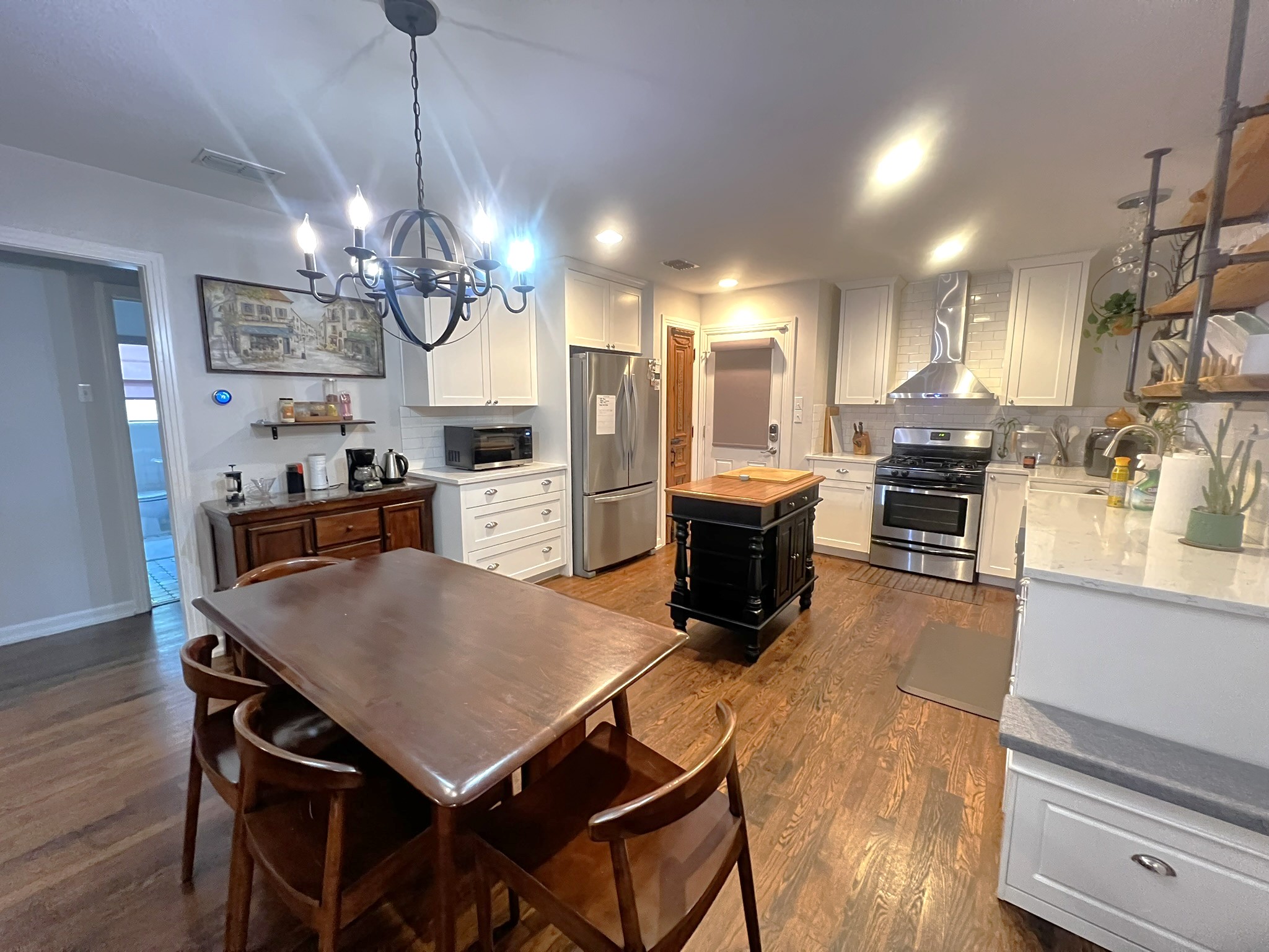 1311 Aggie Lane, Unit A Austin, TX 78757 - Photo 4 of 13 Kitchen featuring stainless steel appliances, wall chimney exhaust hood, a kitchen island, and tasteful backsplash