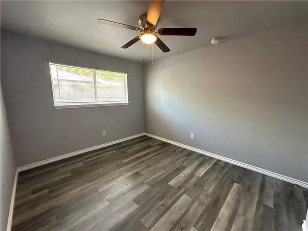 an empty room with closet and a ceiling fan