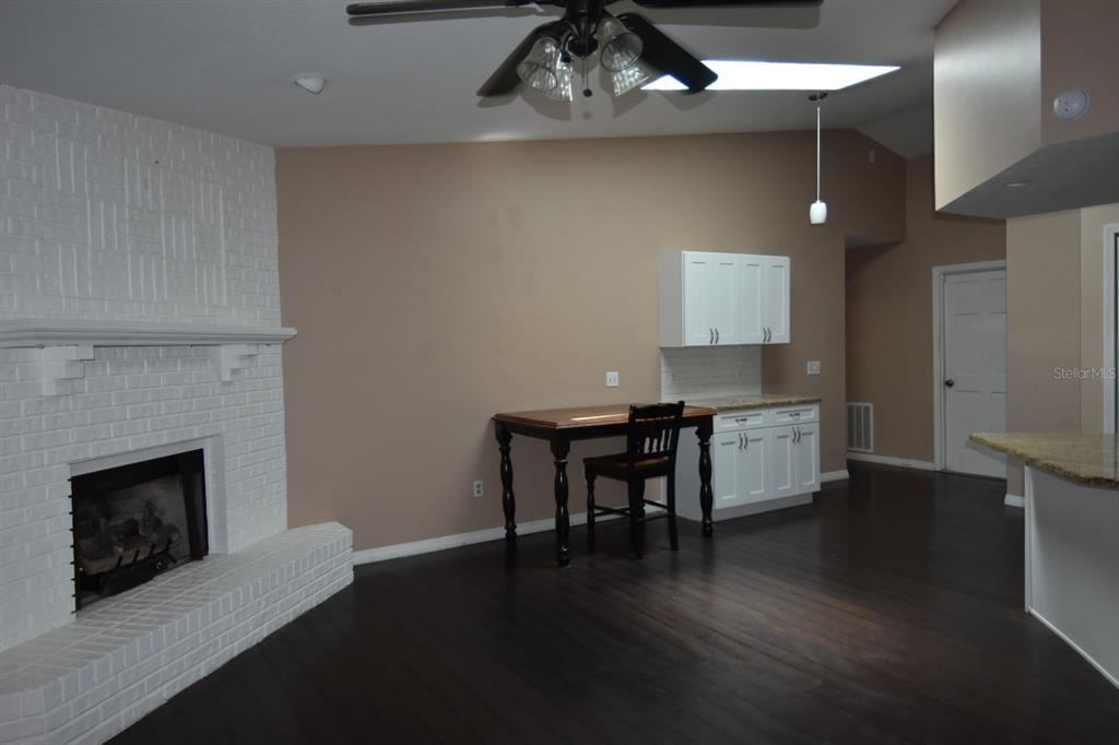 678 Fairchild Avenue Deltona, FL 32725 - Photo 15 of 45 a kitchen with a wooden floor and a fireplace