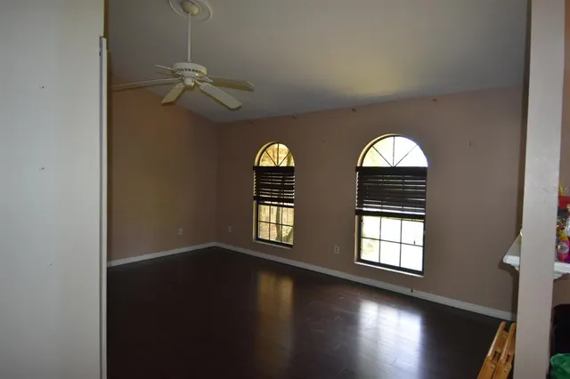 an empty room with windows and fan