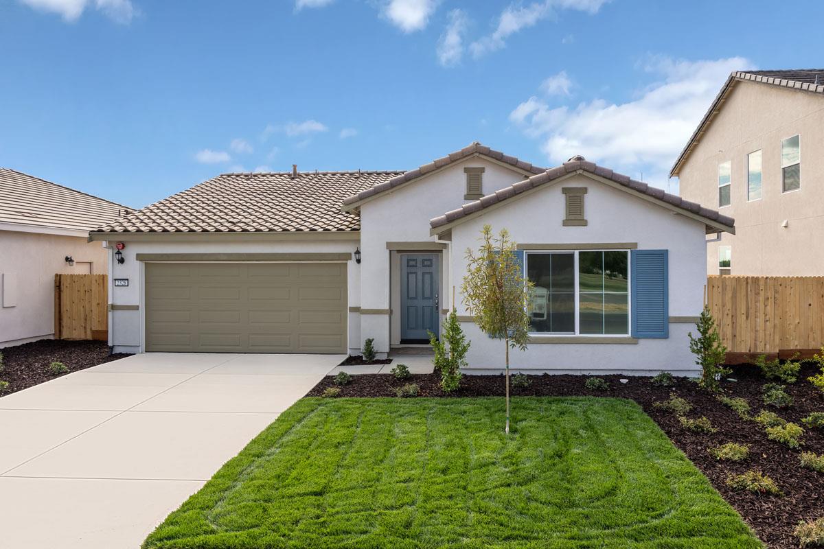 a front view of a house with a garden and plants