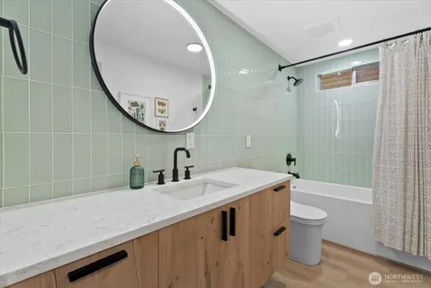 a bathroom with a sink a toilet and a mirror