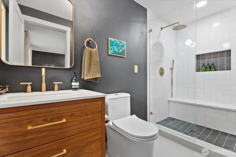 a bathroom with a sink a toilet and mirror