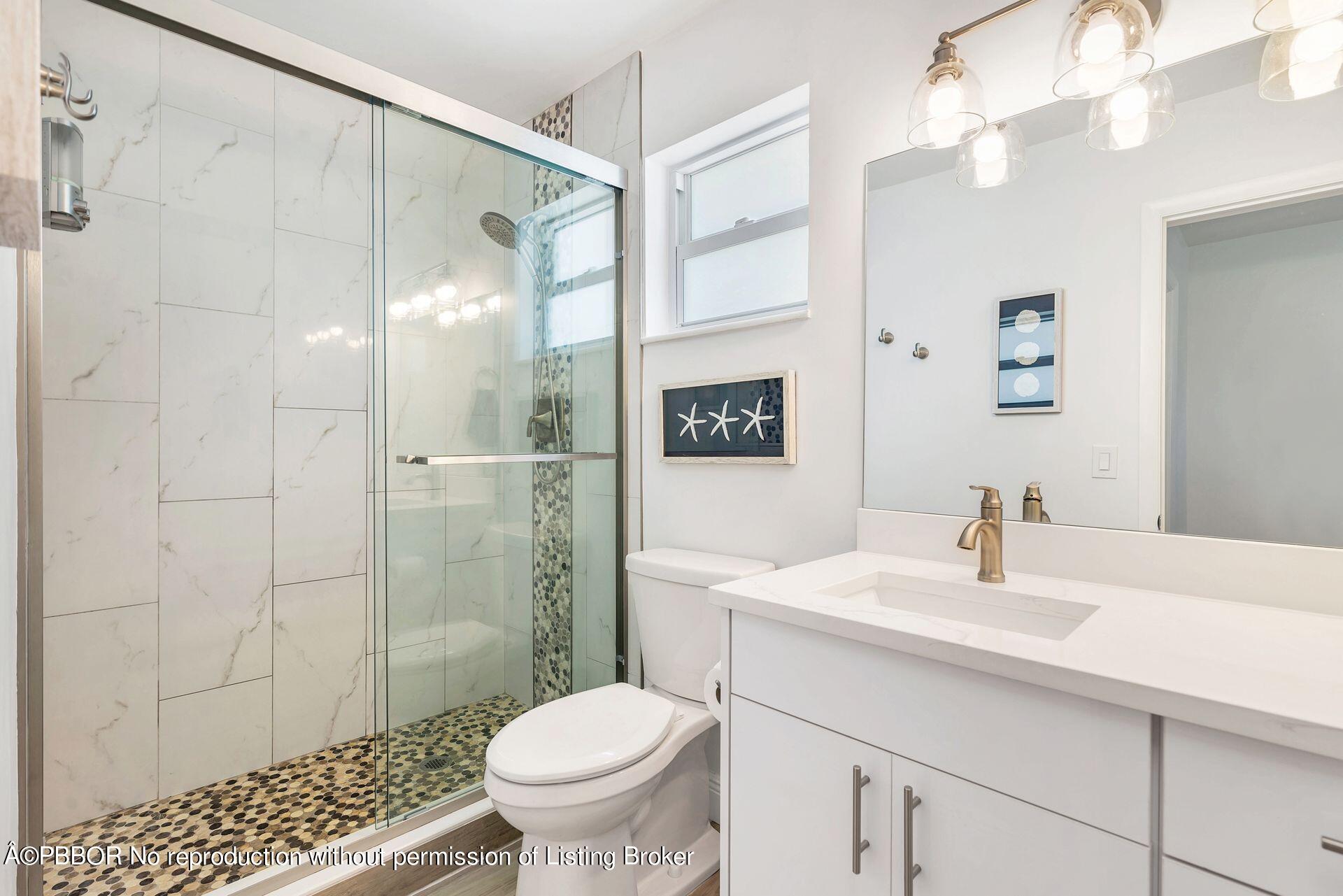 1408 Indian Road East West Palm Beach, FL 33406 - Photo 24 of 50 a bathroom with a sink toilet a mirror and shower