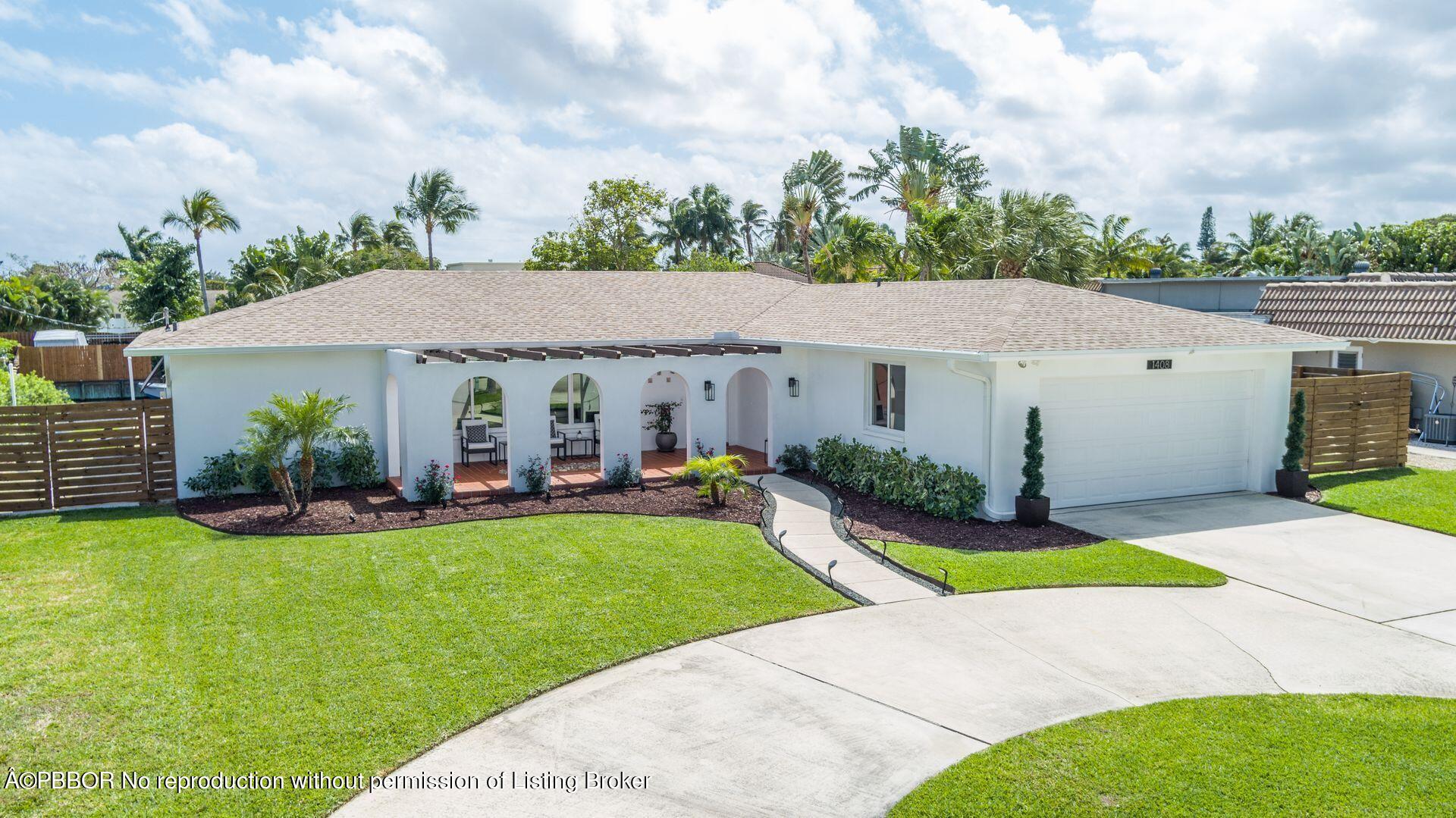 1408 Indian Road East West Palm Beach, FL 33406 - Photo 40 of 50 a view of a white house with a yard potted plants and a table