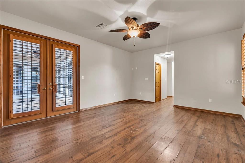 10597 Southwest Kissimmee Road Arcadia, FL 34269 - Photo 21 of 54 a view of an empty room with wooden floor and a window