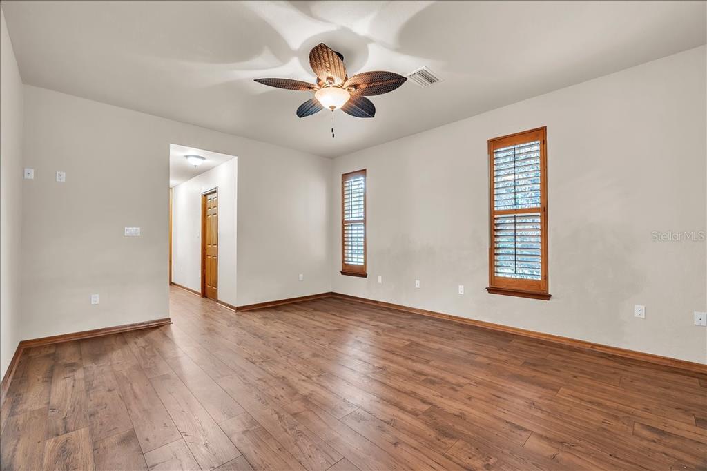 10597 Southwest Kissimmee Road Arcadia, FL 34269 - Photo 22 of 54 a view of an empty room with wooden floor and a window