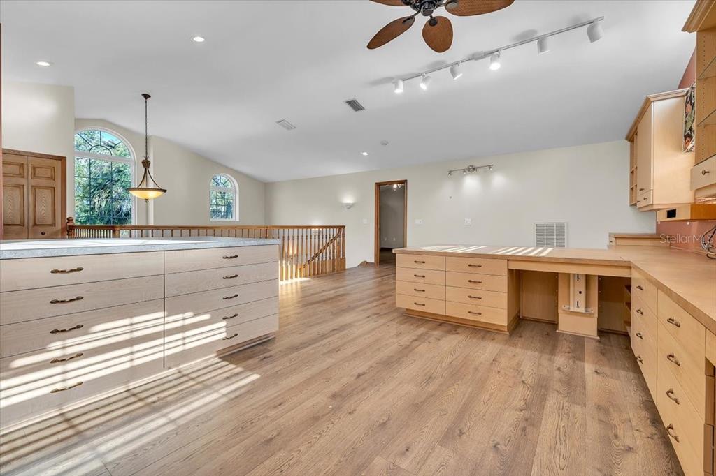 10597 Southwest Kissimmee Road Arcadia, FL 34269 - Photo 32 of 54 a large kitchen with stainless steel appliances a large counter top a stove a chimney a sink and a hard wood floor