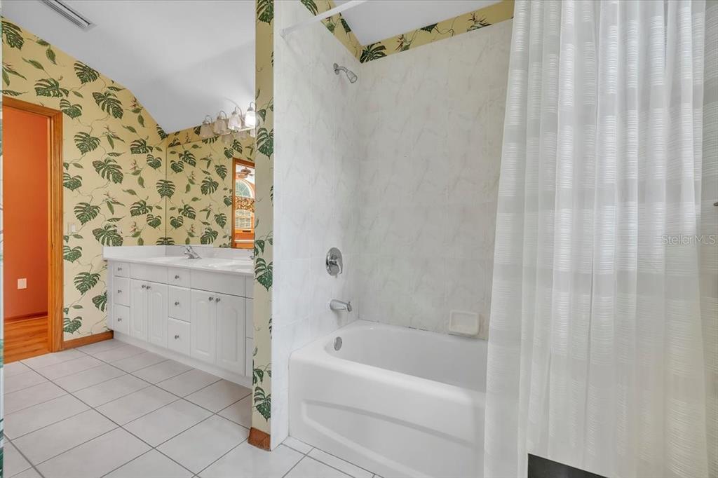 10597 Southwest Kissimmee Road Arcadia, FL 34269 - Photo 37 of 54 a bathroom with a bathtub a sink and a shower curtain